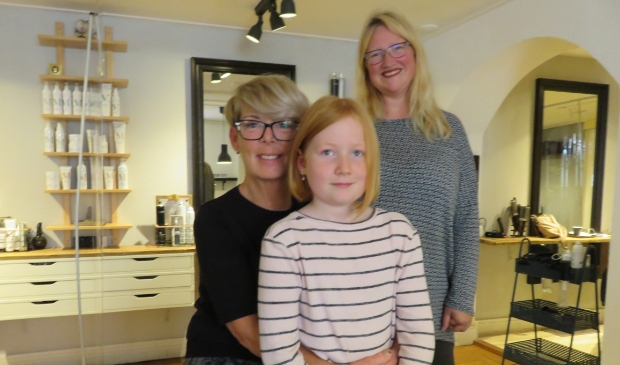 <p>De trotse Isis met haar korte haar, kapster Monique en moeder Mieke (rechts).</p>