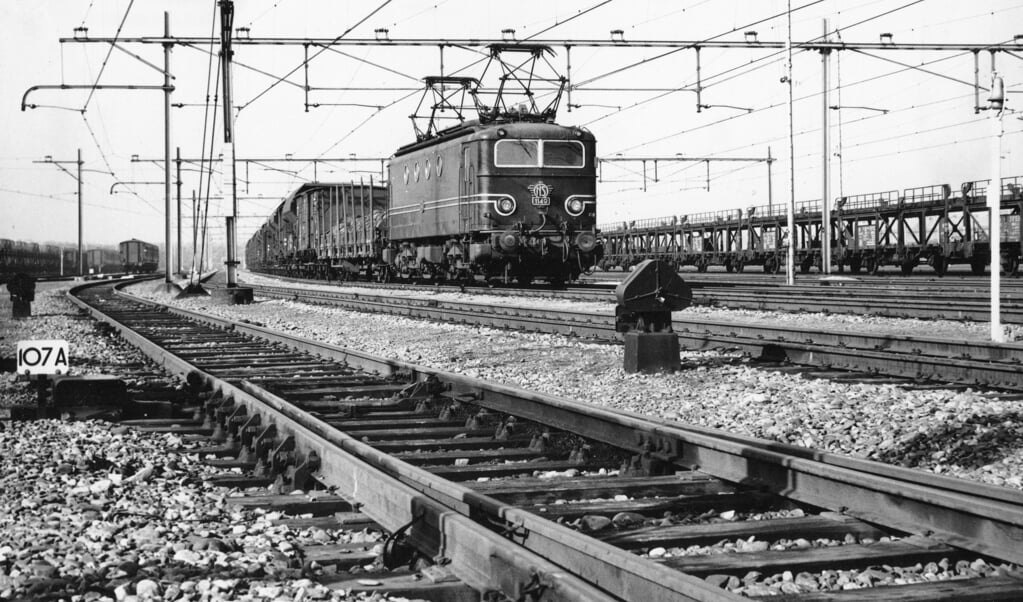 Rechts van de locomotief uit de 1100-serie een autotrein die Volkswagens afgeleverd had aan Pon’s Automobielhandel. (1962). 