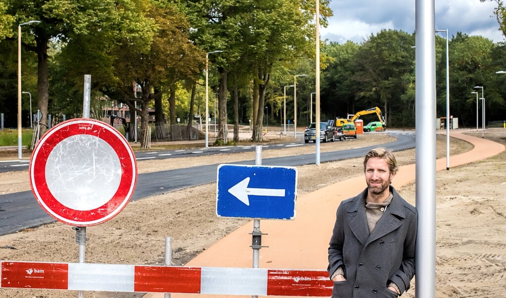 Marco te Brömmelstroet tussen het asfalt en de verkeersborden aan de Parklaan in Ede.