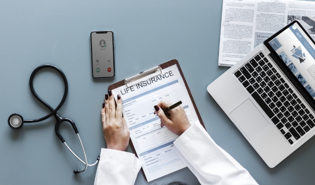 Doctor filling up a life insurance form