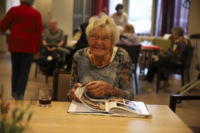 Bewoners genieten van alle herinneringen uit het jubileumboek.
