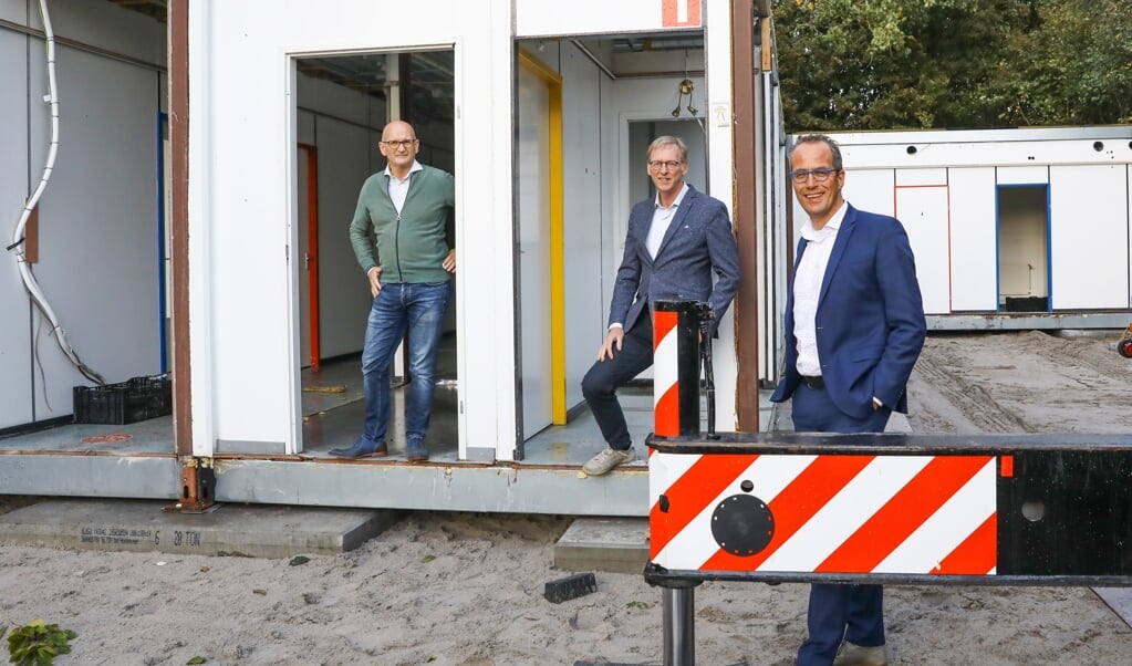 Henk Buitink (Sparta Korfbal), Klaas Maarten van Slooten (Voedselbank Nijkerk) en wethouder Harke Dijksterhuis nemen een kijkje bij het plaatsen van de units.