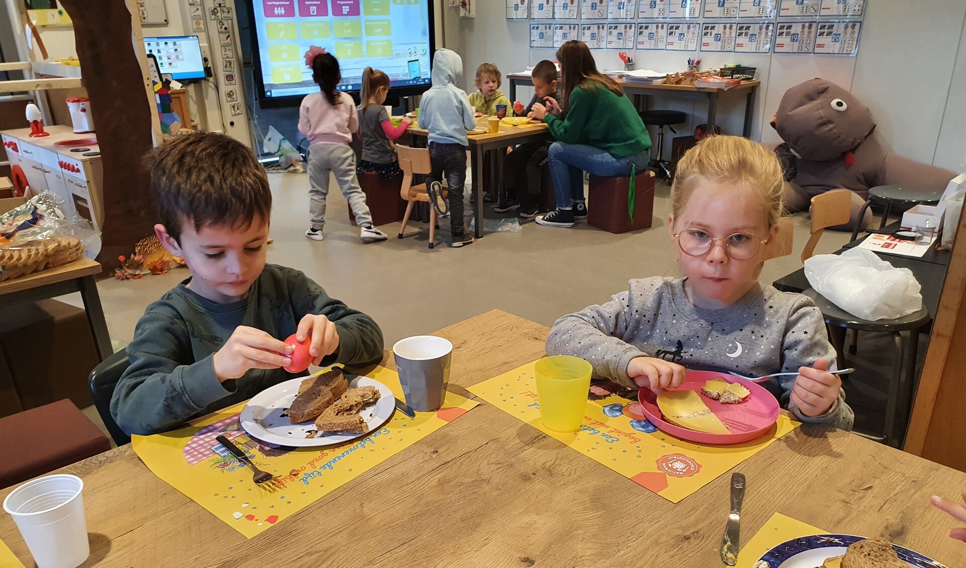 kinderen van de onderbouw genieten met elkaar van hun gezonde ontbijt