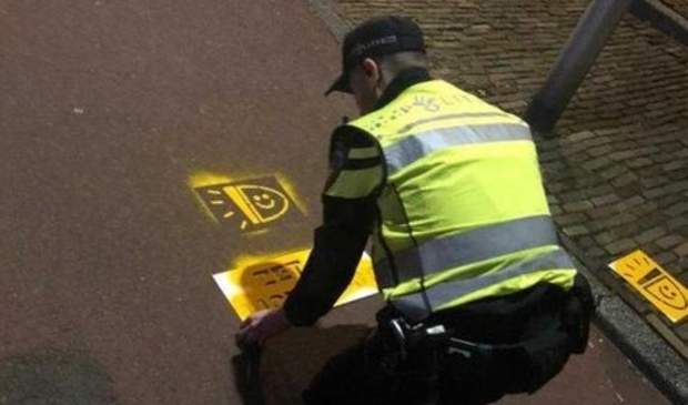 <p>Agent brengt oproep aan fietsers om het fietslicht aan te zetten aan op het wegdek. </p>