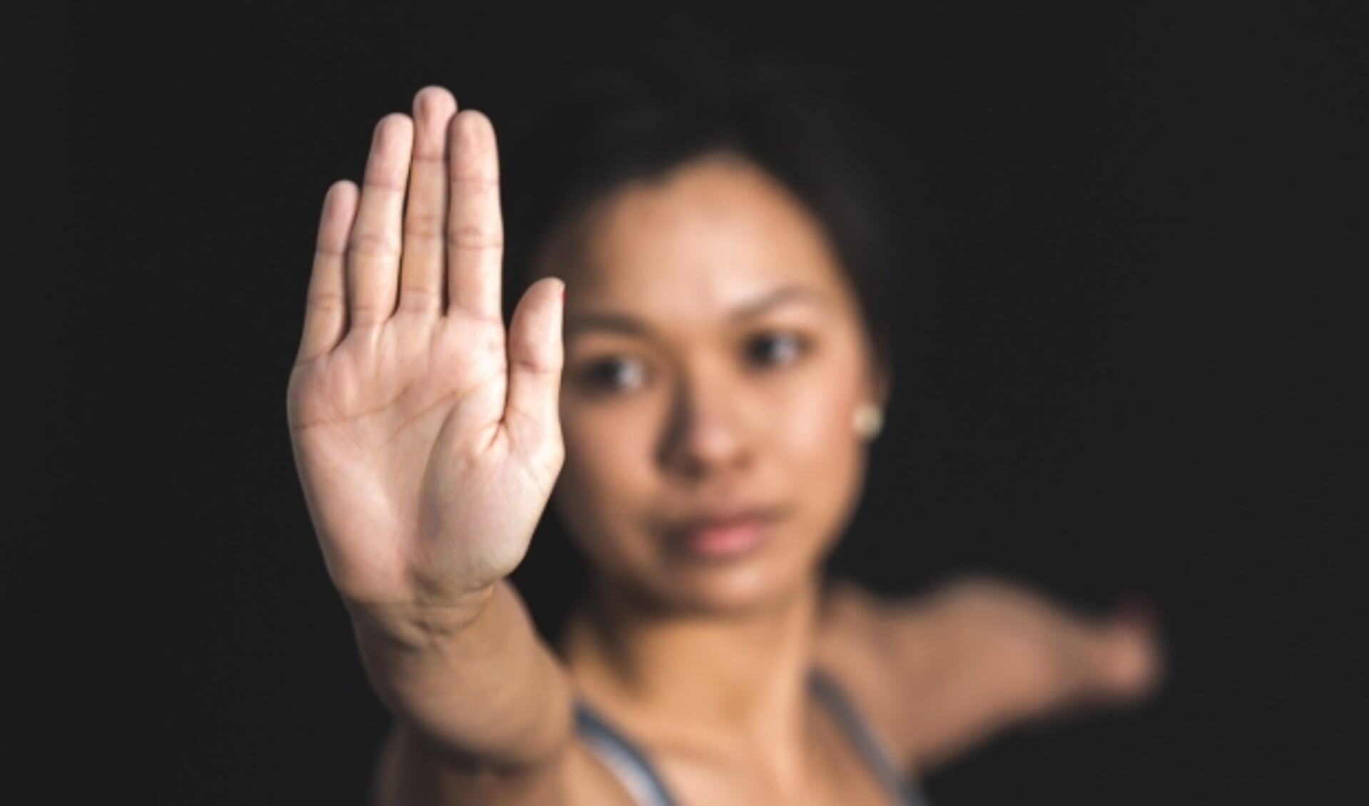Een vrouw die haar hand opheft als teken: stop het geweld. Foto: Via pexels.com Fotograaf: Burst