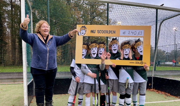 Jongens Shinty JF2-1 geven cheque aan Linda Platvoet van de Voedselbank Utrechtse Heuvelrug