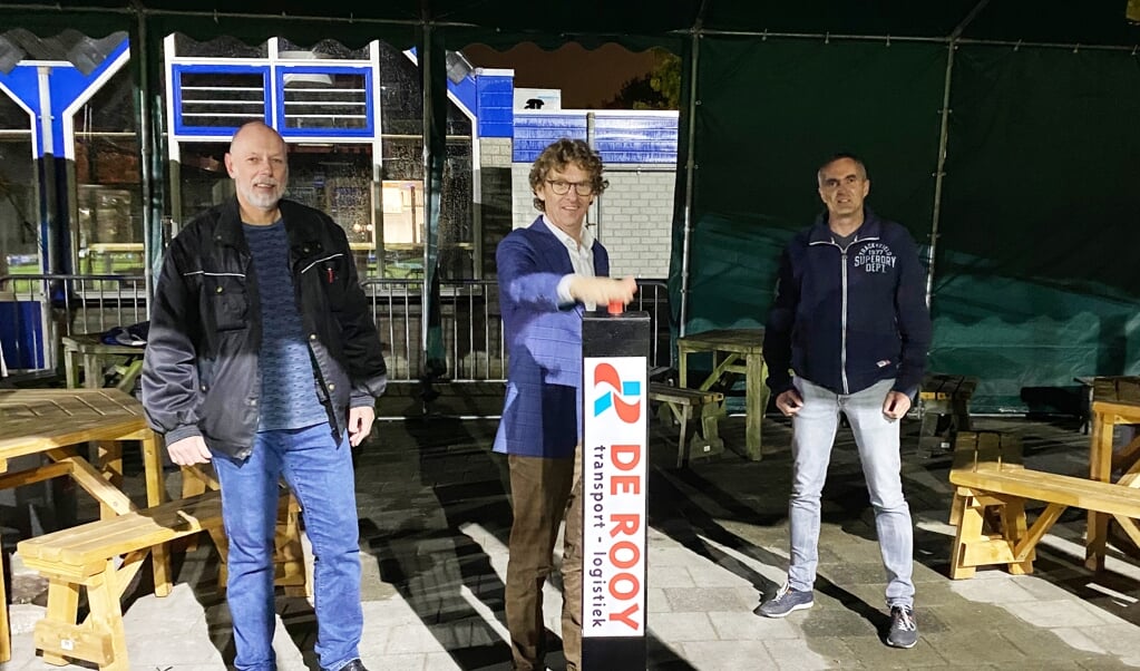 Wethouder Kan Overweg stelt in aanwezigheid van voorzitter Henk van Garderen (l) en penningmeester Edwin de Ligt (r) met een druk op de knop de LED-verlichting in werking.  