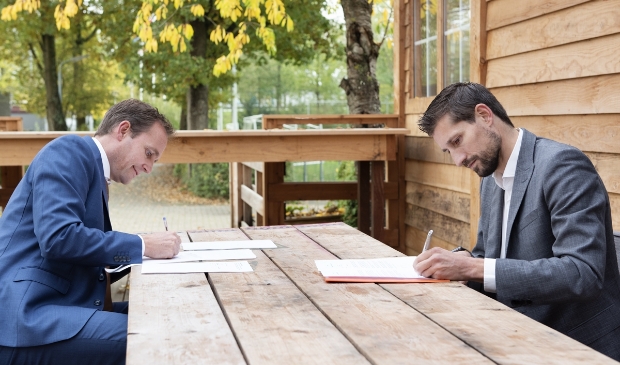 <p>Ronald van Bemmel, directeur Softs (links) en Eelke Kraaijeveld, wethouder Duurzaamheid tekenen de overeenkomst</p>