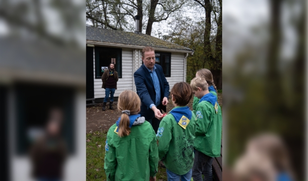 Wethouder Frank Berkhout reikt Amstelveen insigne uit aan welpen van Scouting Kantankye
