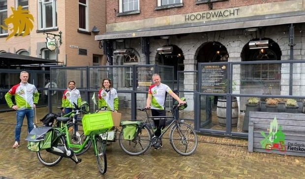 <p>Marcel Herrewijn van de Fietskoerier poseert samen met Pien Bogaard, Rene Joosen en Monica de Ras voor de Hoofdwacht</p>