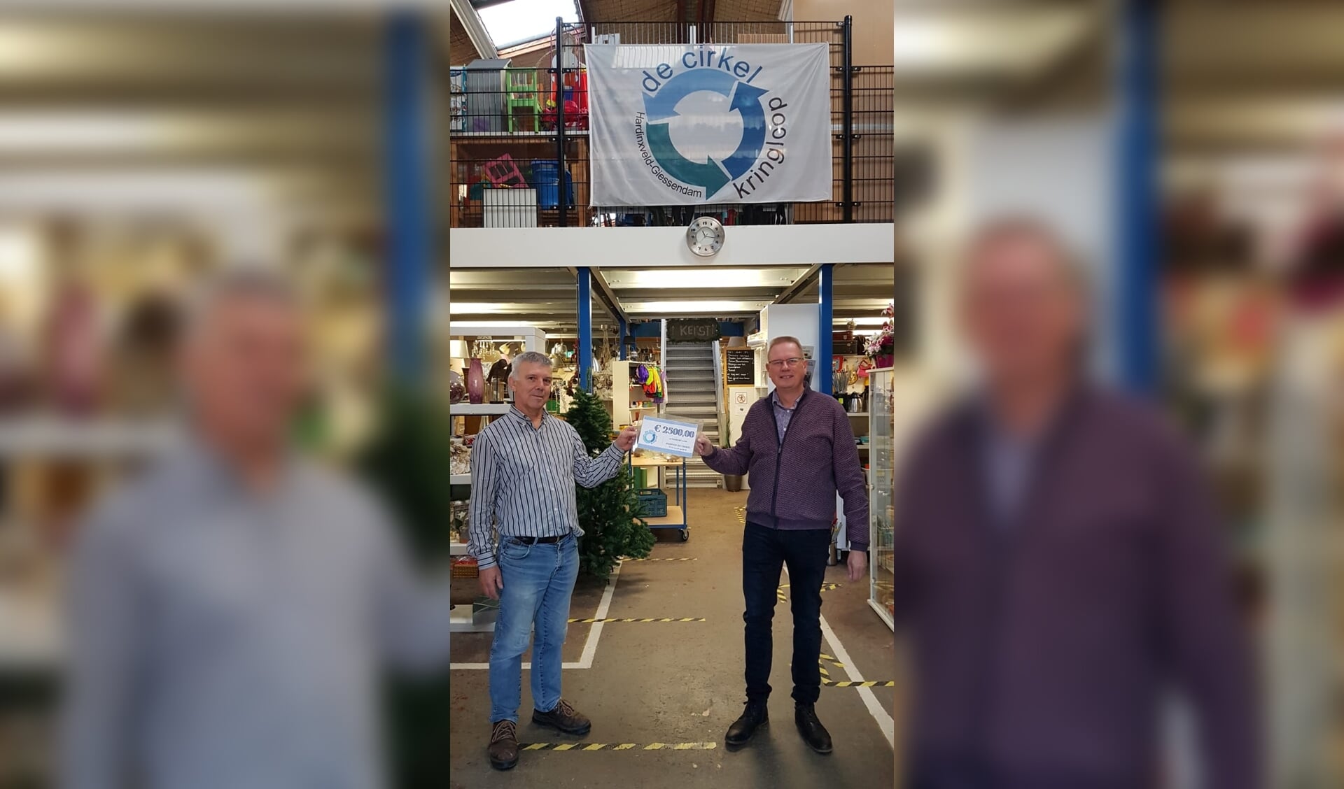 Uit handen van Jan de Rooij, voorzitter kringloop De Cirkel, ontvangt Nico van der Veen, Stichting vrienden van hospice De Cirkel, een cheque van 2.500 euro.