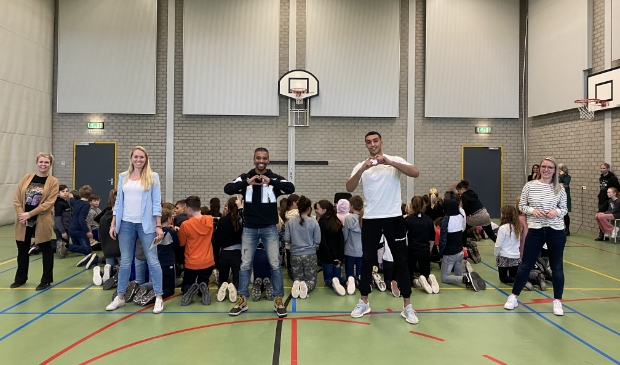 Collega's van Opmaat poseren samen met Imad en Brahim.