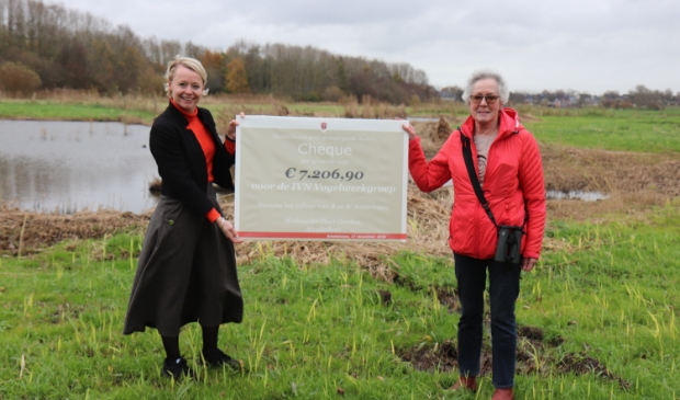 <p>Wethouder Floor Gordon overhandigt de cheque aan Marleen Andriessen van de vogelwerkgroep.</p>