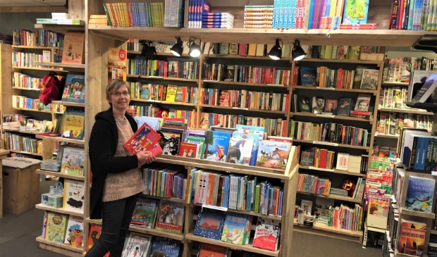 Mieke vd Boomgaard trots bij één van de nieuwe boekenkasten