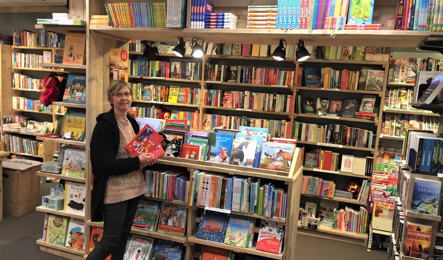 Mieke van den Boomgaard presenteert trots één van de nieuwe boekenkasten
