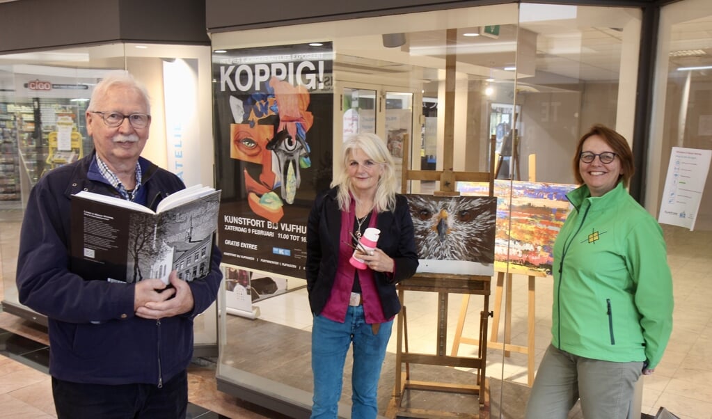 Piet Kwak van de dorpsraad, kunstenares Anne-Marie Corman en Louise van Zandvoort van de dorpsraad voor de winkelpui 'van Pier K.'.
