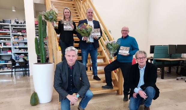 Peter Beijer (links) en Lex Bergers reikten de eerste boeken uit aan Marloes en Martijn Martens en Jaap van den Broek