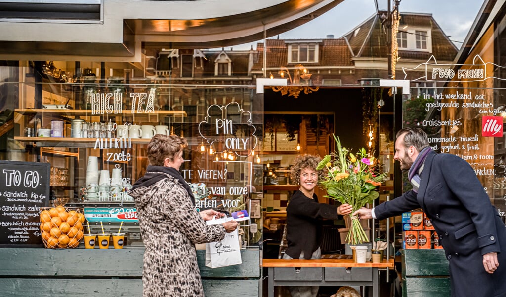 Wethouder Joost van der Geest verwelkomt Marloes van den Berg van Espressobar Hugo als 100e deelnemer aan de Bliekenbon. Links op de foto: Binnenstadmanager Nita van Wijngaarden.