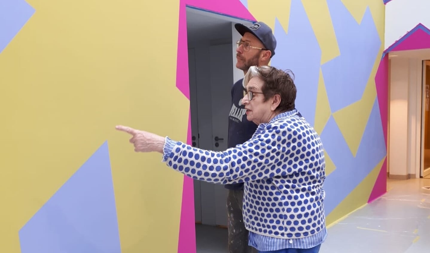 Henriëtte van ‘t Hoog bekijkt de door haar ontworpen muurschildering in de entree van het Mondriaanhuis.