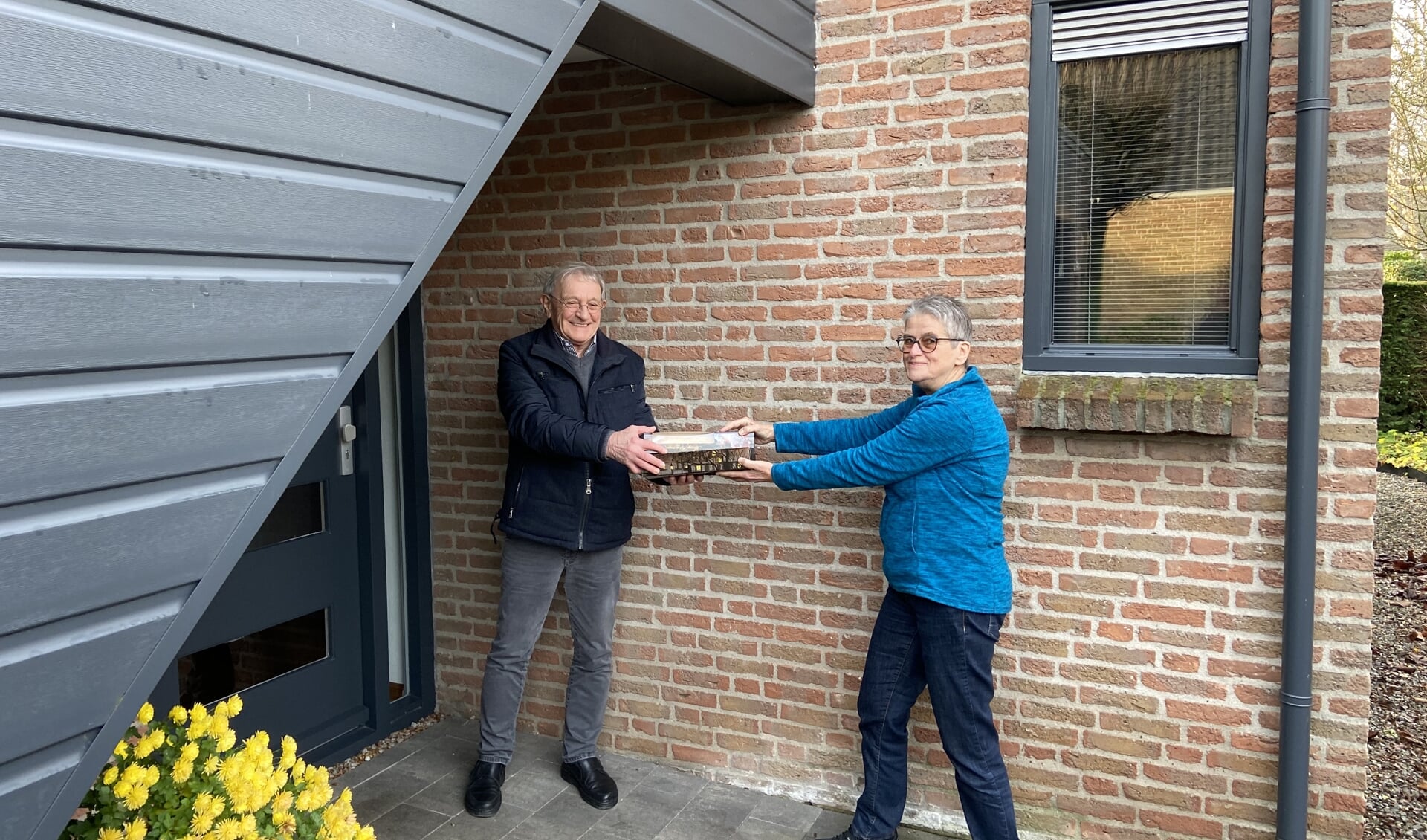 Bert van Rossum overhandigt staven en kaarten aan Wies Maas, beiden Zonnebloemvrijwilliger