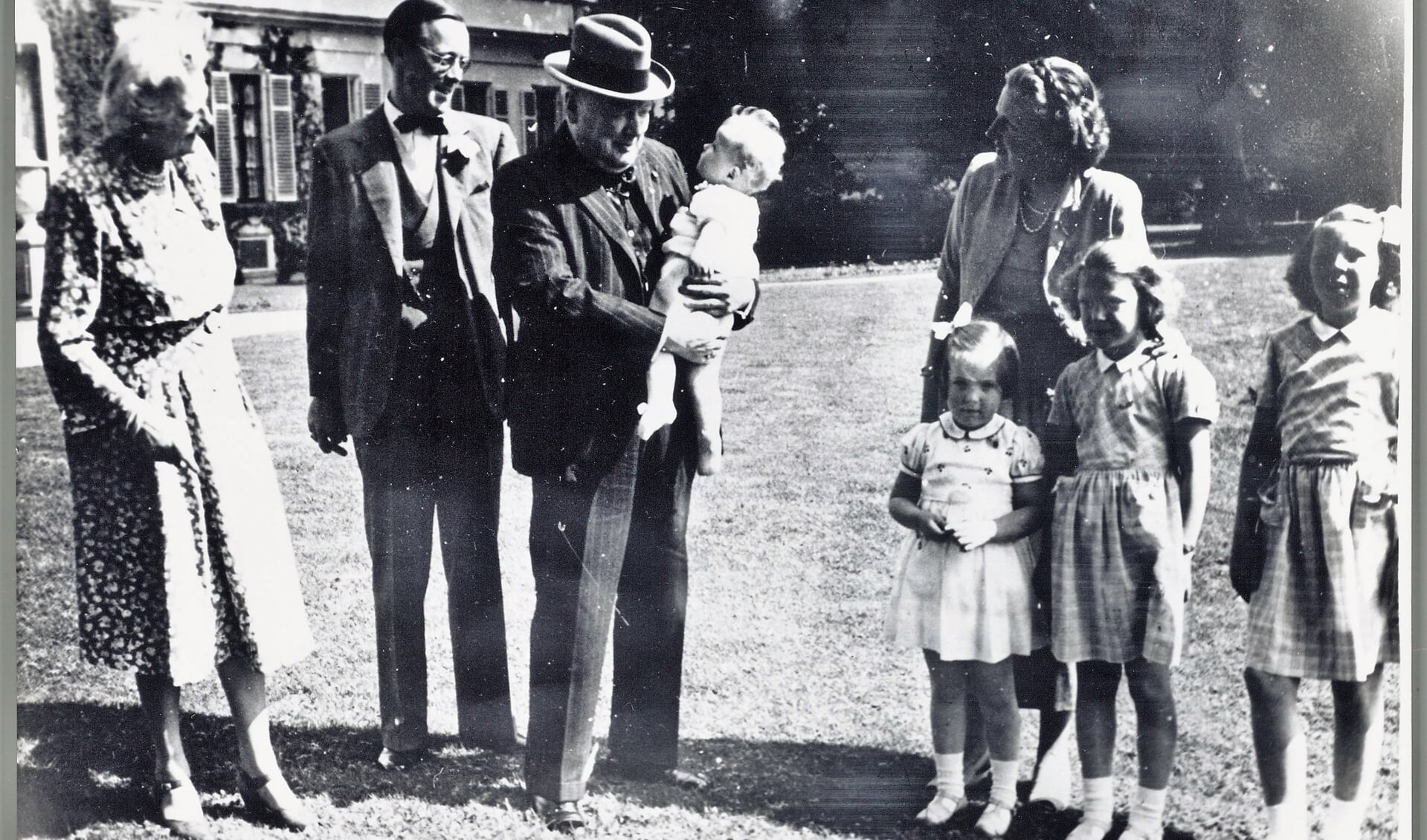 Winston Churchill in mei 1948 in de tuin van Soestdijk, met, toen nog, prinses Marijke op zijn arm. 
