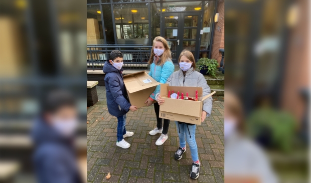Marwan, Tessa en Eline van de Valkenheuvel met de dozen vol kerststukjes.