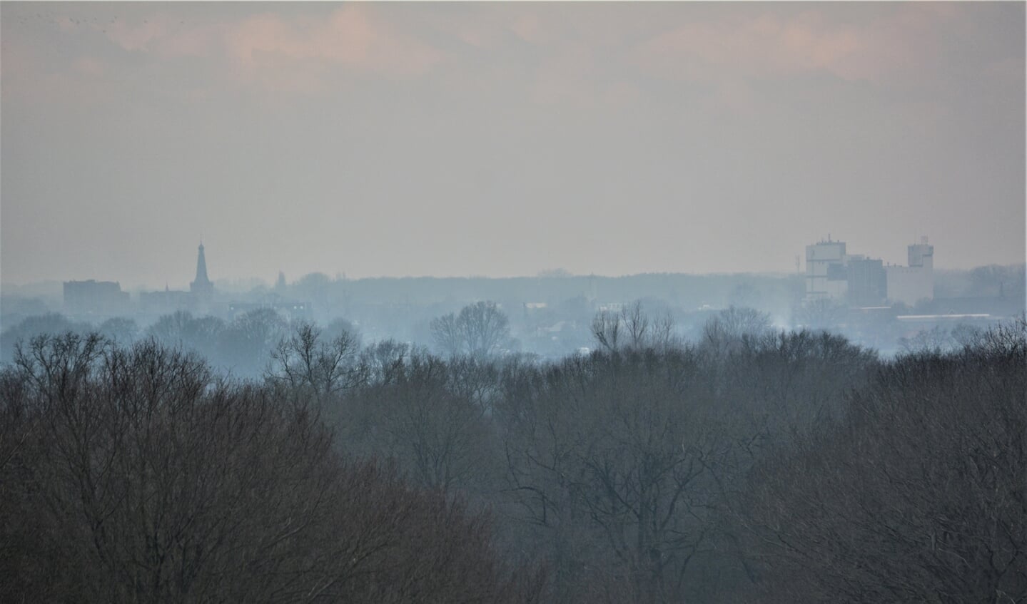De skyline van Barneveld gevangen in nevel en rook van 'vreugdevuurtjes'.