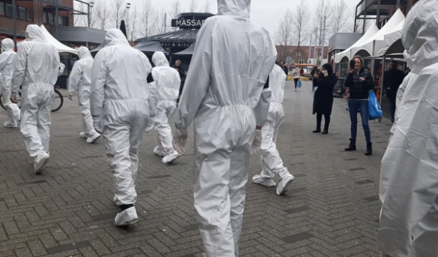 <p>Omstanders reageren verbijsterd bij het zien van de ingepakte mensen. </p>