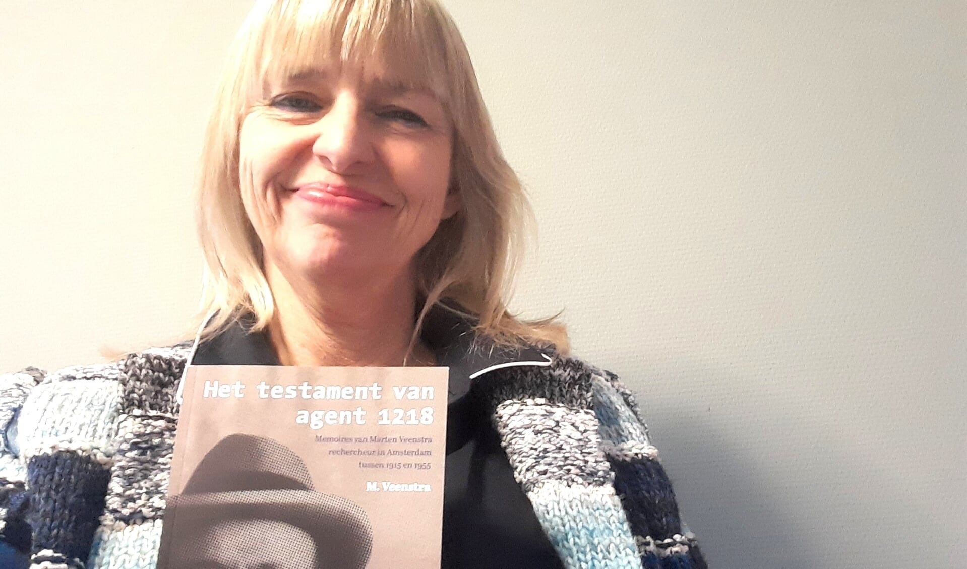 Monique Veenstra met het boek dat ze over haar grootvader, de Amsterdamse politieman Agent 1218, schreef.