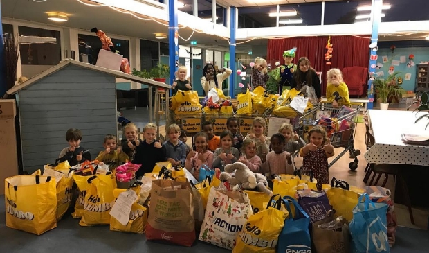 De kinderen van de Kofschip BSo van Tante Kaatje, tussen alle ingezamelde lekkernijen en cadeautjes