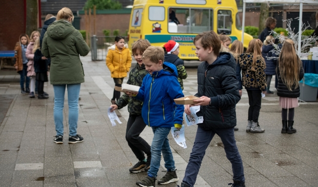 Kinderen gaan met hun lekkers naar de klas.