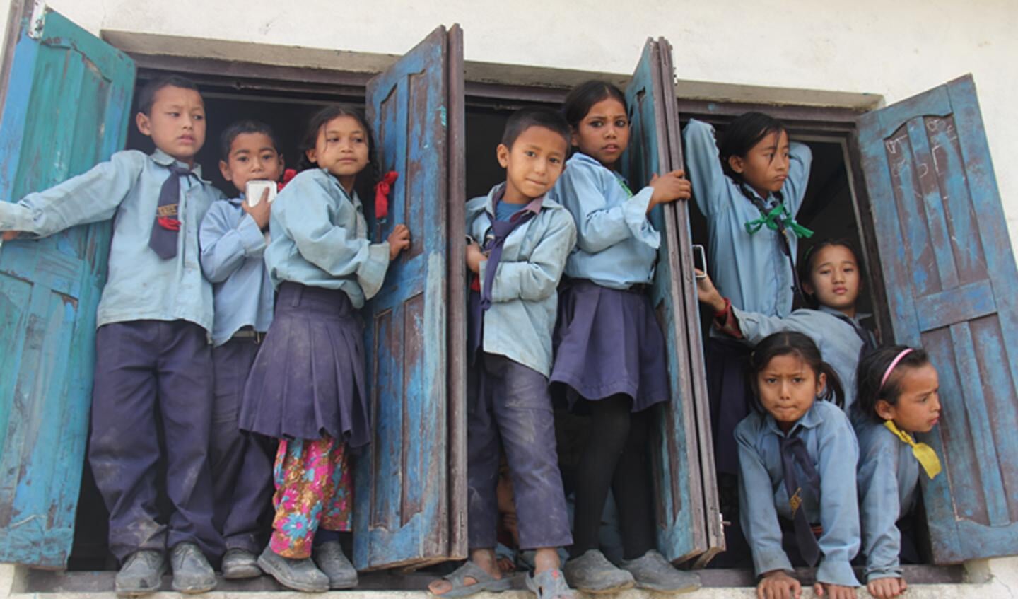 Kinderen poseren in de pauze in de opens schoolramen