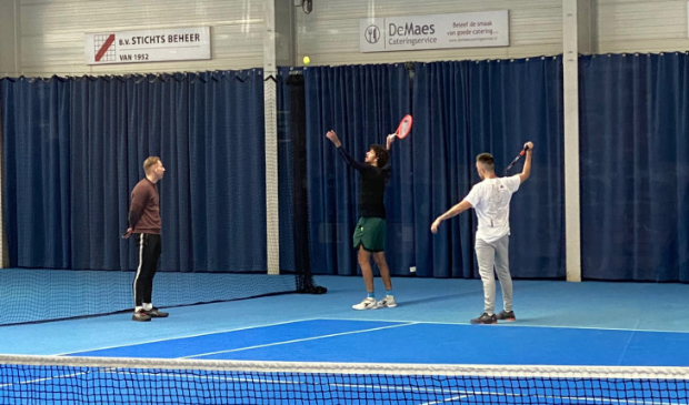 <p>Toptennisser Haase (middelste persoon) legt Romero (rechts) uit hoe hij het best kan serveren.</p>