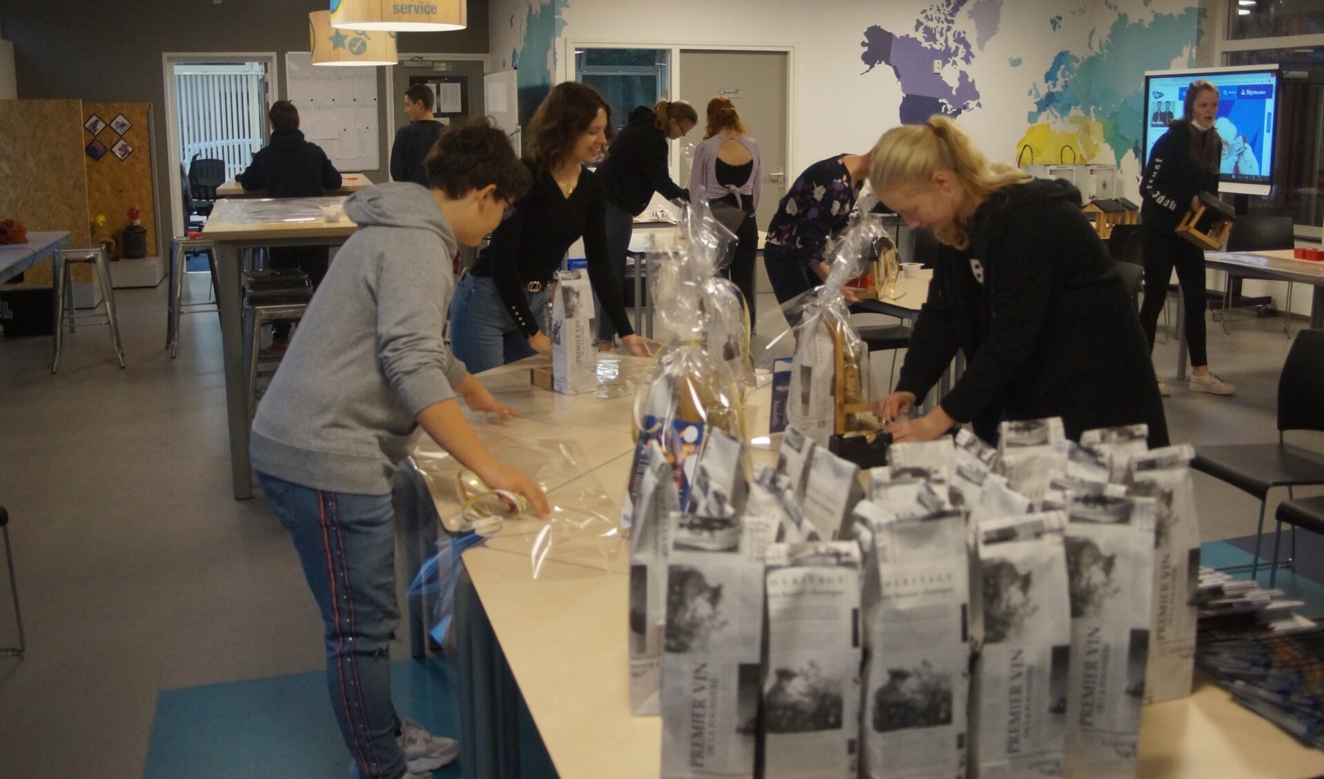 Leerlingen zijn druk met het inpakken van de kerstpakketten voor de vrijwilligers van Welzijn Putten.