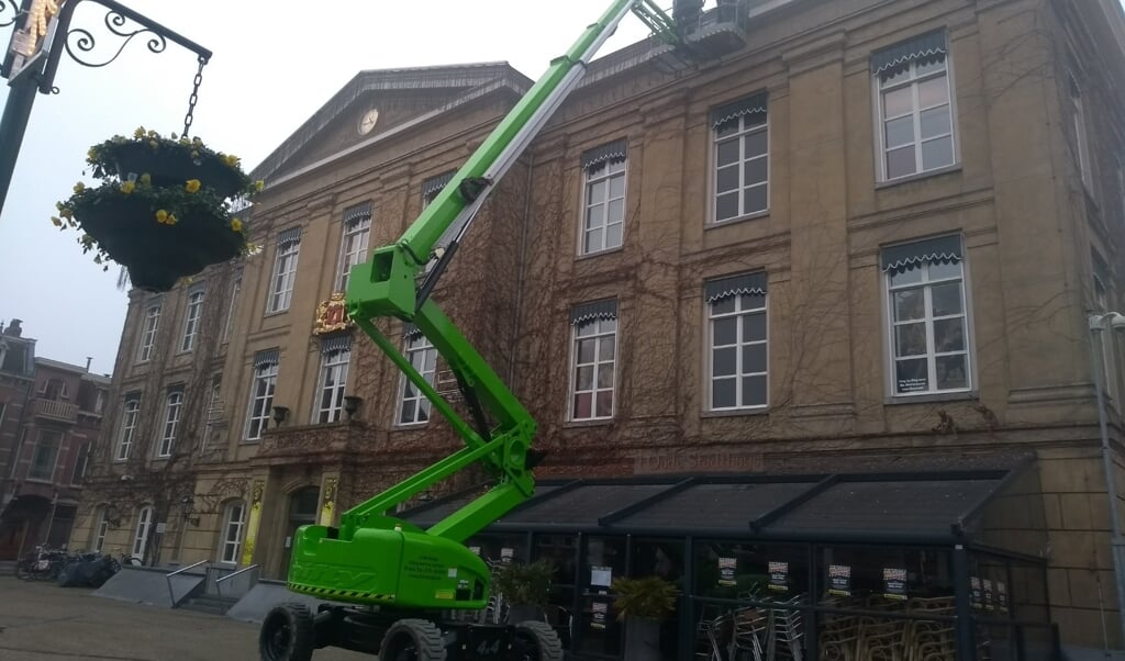 Met de hoogwerker worden de lichtjes opgehangen bij het museum