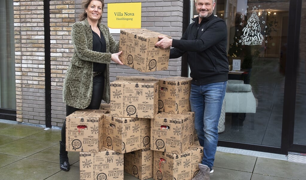 Jeroen Dammers van Jeroens Paviljoen in De Hamershof overhandigt de kerstpakketten aan locatiemanager Marieke van Ekdom.