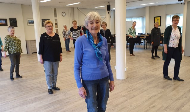 Op de voorgrond Greet tijdens een les linedance. Dansen en bewegen is haar lust en leven.