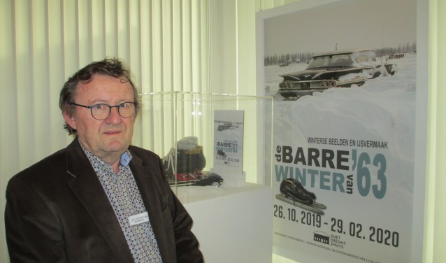 Bert den Boer bij het affiche met de ingesneeuwde taxi van Jan Rozendaal.