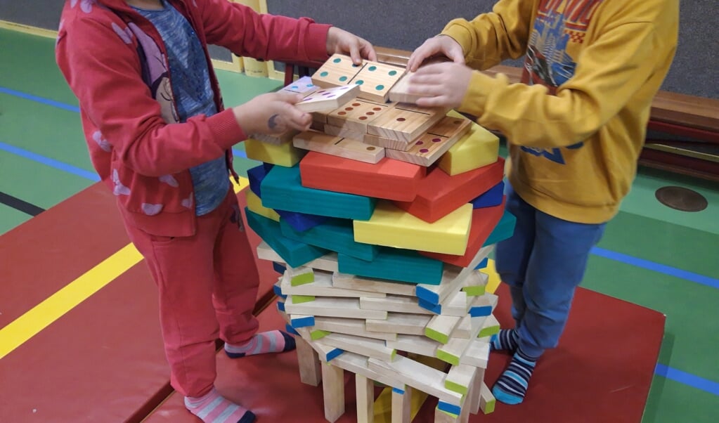 Kinderen bouwen mooie torens met elkaar. 