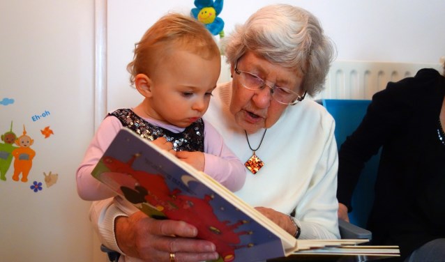 Voorlezen, puzzelen, een praatje. Contact tussen senior en peuter.