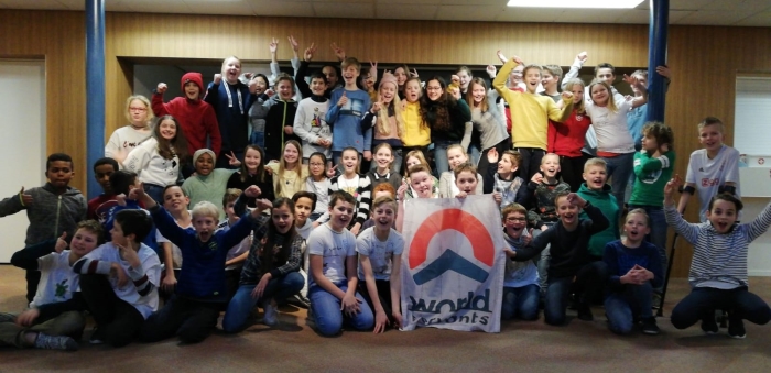 De groepen 7, 8a en 8b van de Koepelschool met de vlag van World Servants