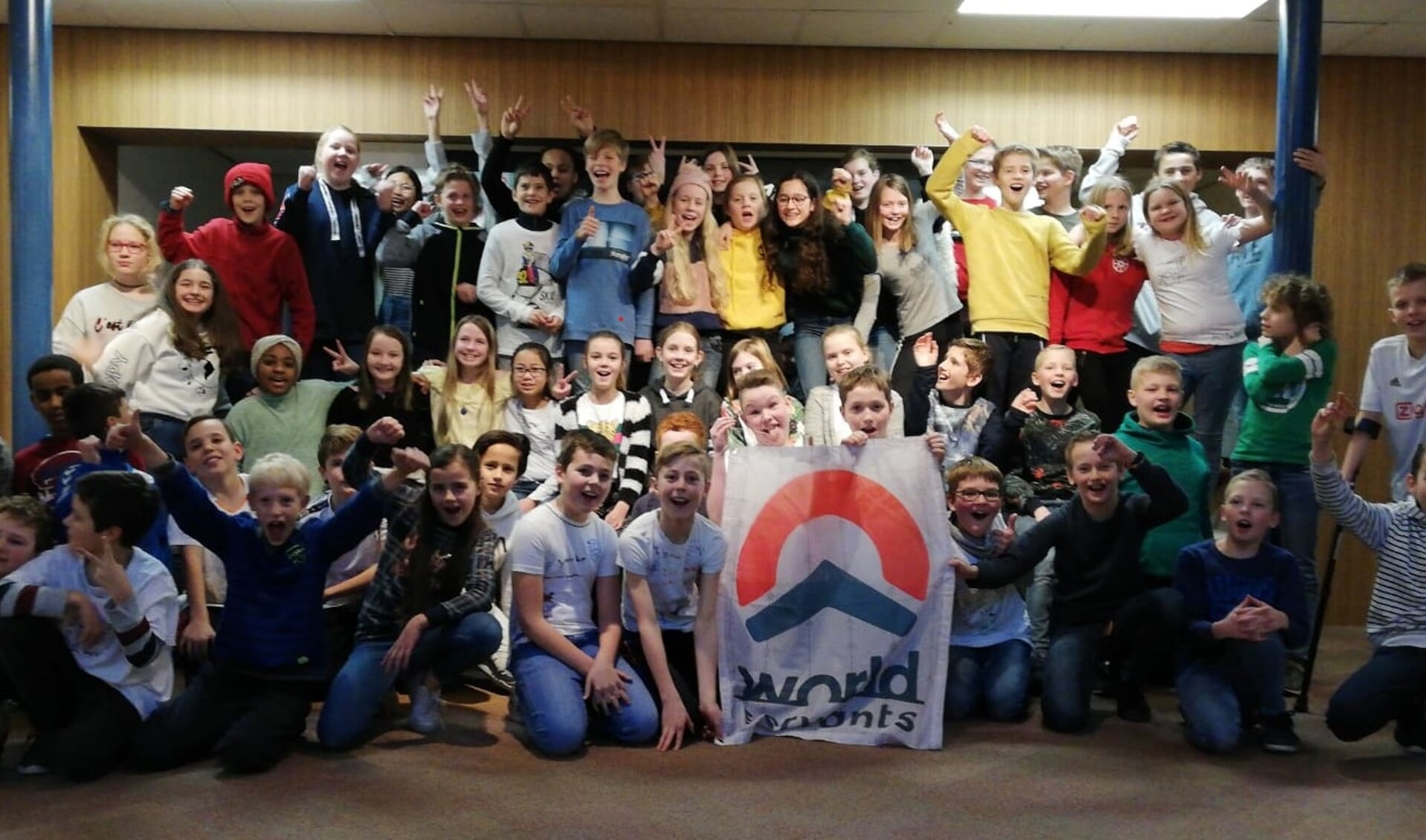 De groepen 7, 8a en 8b van de Koepelschool met de vlag van World Servants