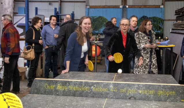 Gedeputeerde Zita Pels en NS Randstad-Noord directeur Irma Winkenius achter de tafeltennistafel gemaakt van hoogwaardige treinvloer.
