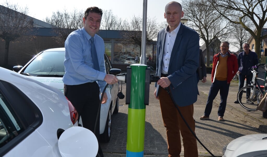 Sander Thomas (Stedin) en wethouder Hans Marchal sluiten in maart 2019 de eerste auto's aan in Cothen. Dit is een paal met gemeentelijke toestemming (archief WijksNieuws)
