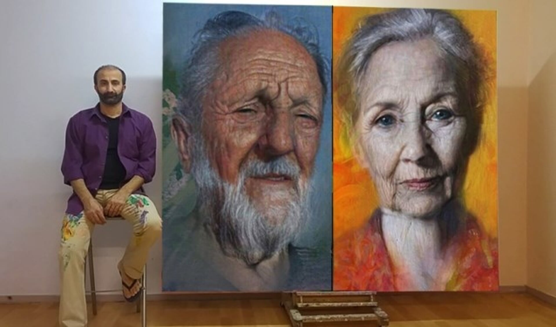 Araz Hama met twee van zijn schilderijen uit de serie Daklozen.