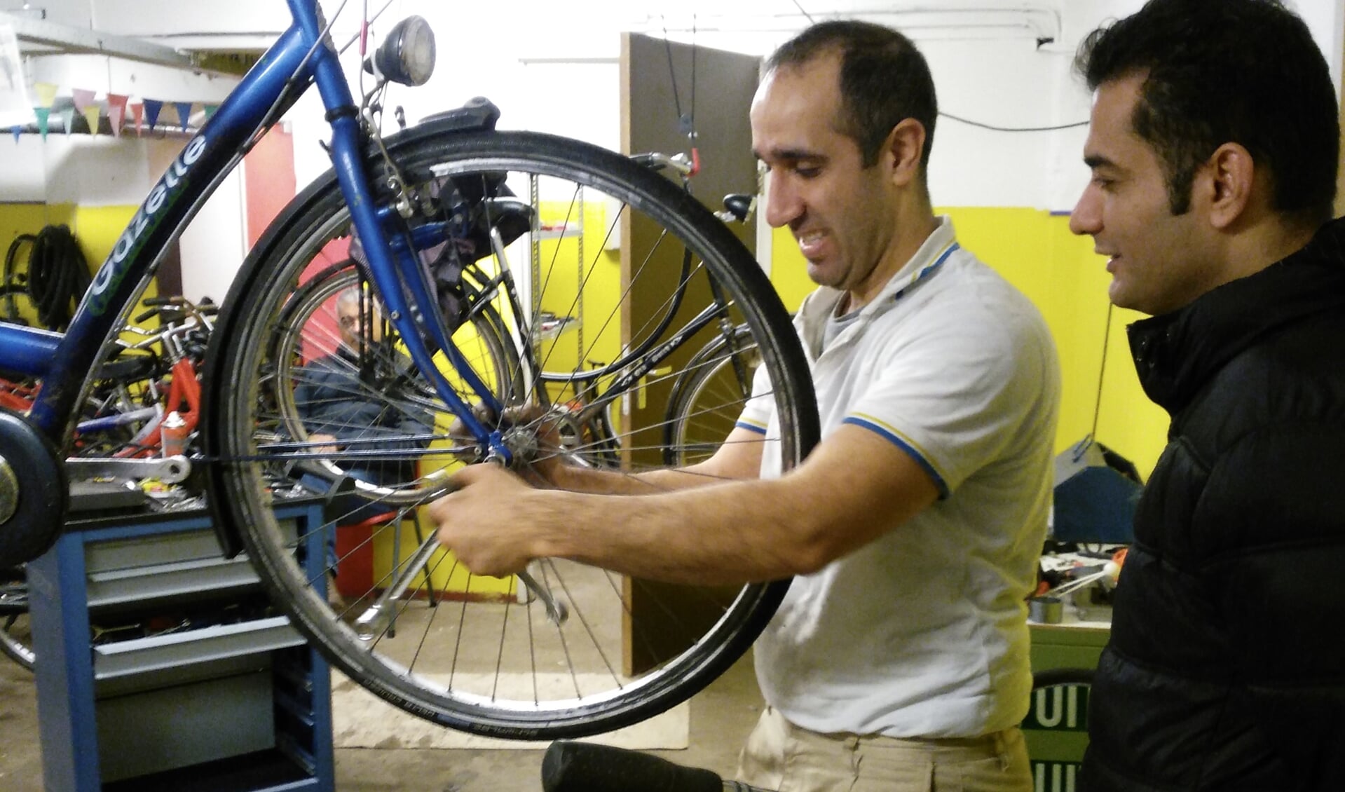 Fietsenmaker Hamidfreza is in de fietsenwerkplaats van het AZC in Leersum bezig met de fiets van een andere bewoner. 