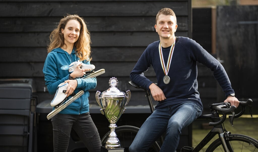 Laura van Ramshorst en Martin van de Pol delen hun liefde voor het schaatsen en wielrennen. In het midden de trofee die Van Ramshorst won met haar zege in de Alternatieve Elfstedentocht.