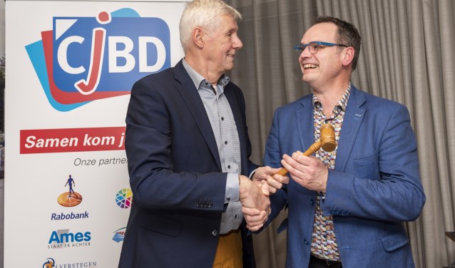 Harry Eskes (l) draagt met de voorzittershamer zijn taken over aan Johan den Houter.