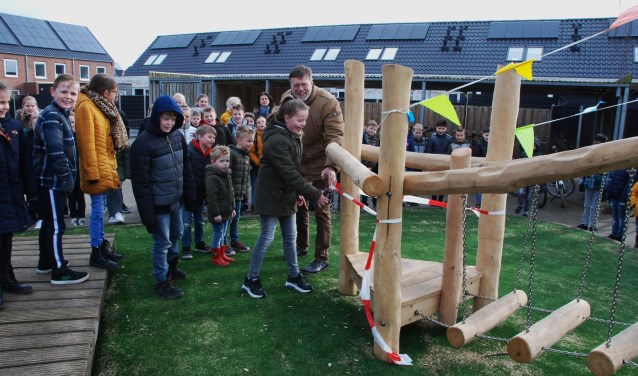 Een groep scholieren mag als eerste het nieuwe speeltoestel inwijden.