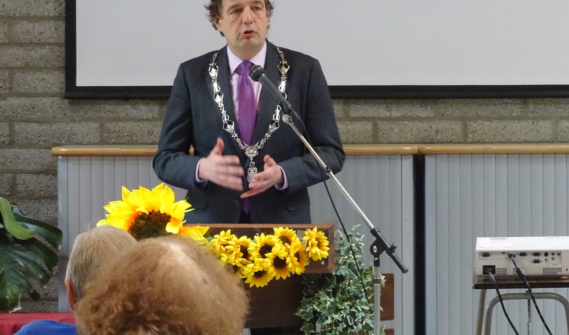 De burgemeester spreekt de feestgangers toe